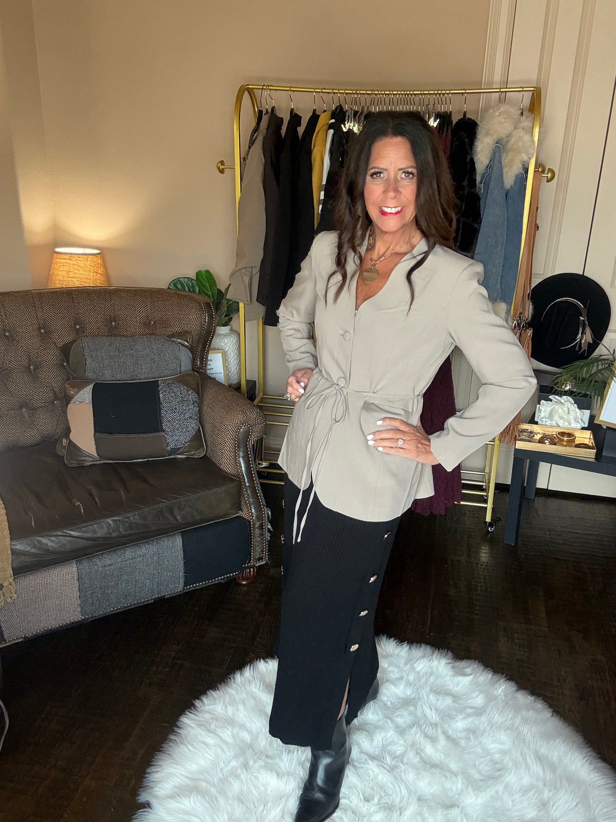 Angled view of the taupe Perfect Layer Lightweight Tie Blazer styled with a white top, black midi skirt and black boots.