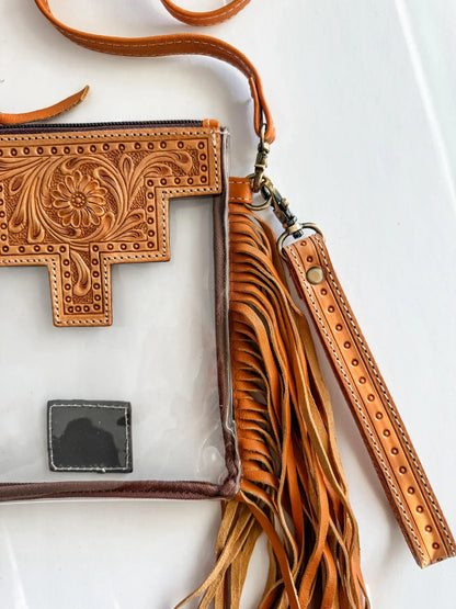 Brown leather crossbody bag with intricate designs on a white background