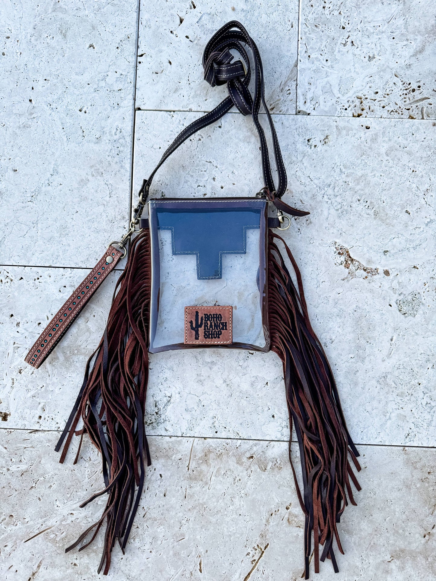 Bag with fringes and a blue interior on a textured surface