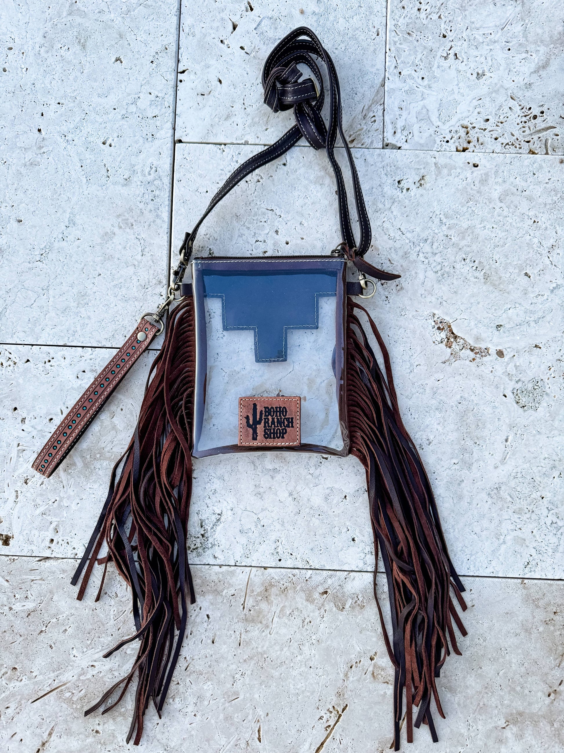 Bag with fringes and a blue interior on a textured surface