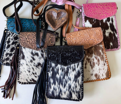 Collection of leather and cowhide bags with intricate designs on a white background