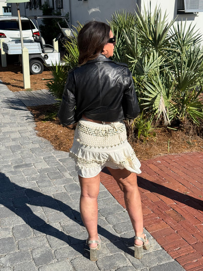 woman modeling cream dress and leather jacket