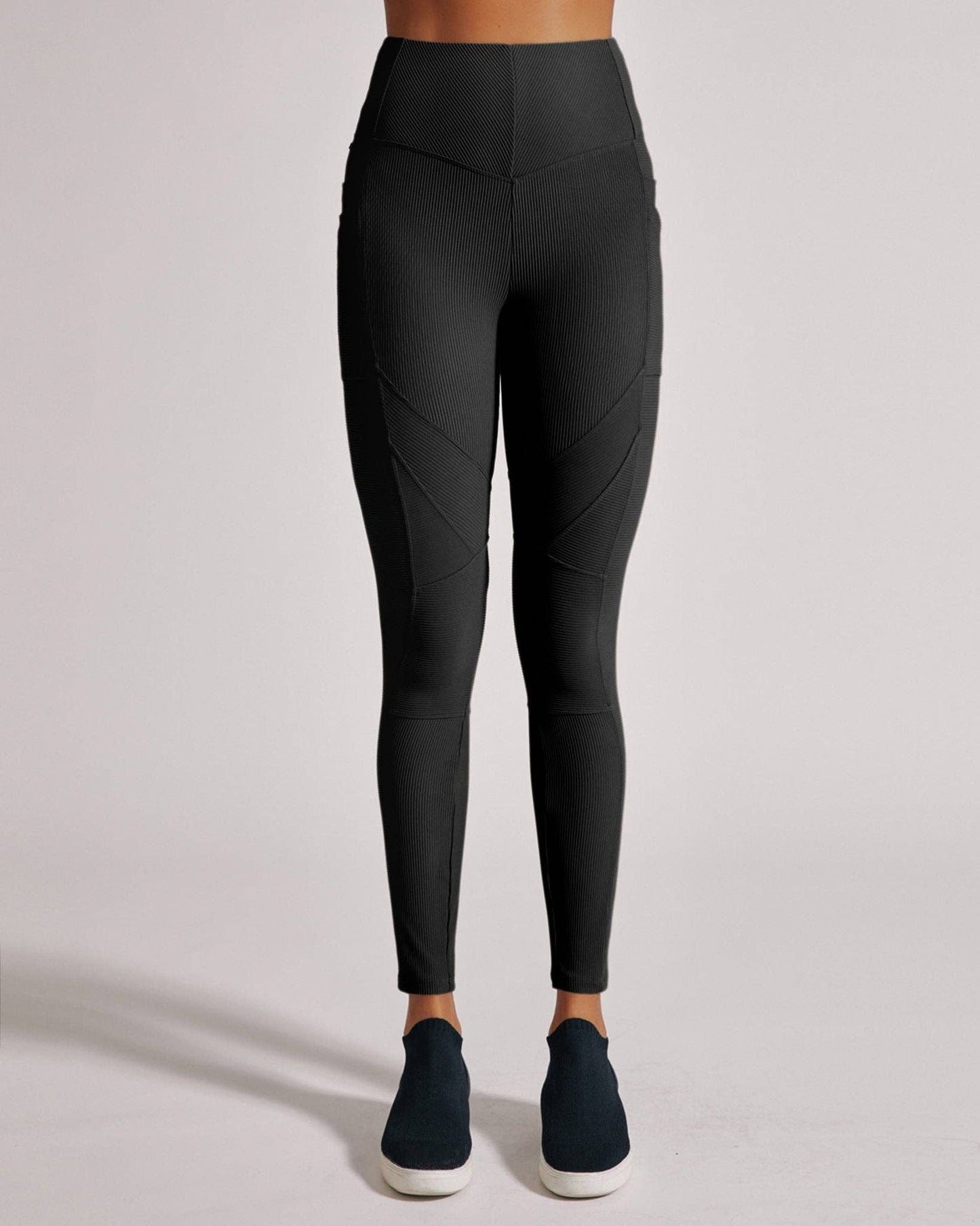 Black leggings worn by a person on a light gray background