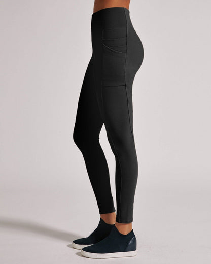 Black leggings worn by a person on a light gray background
