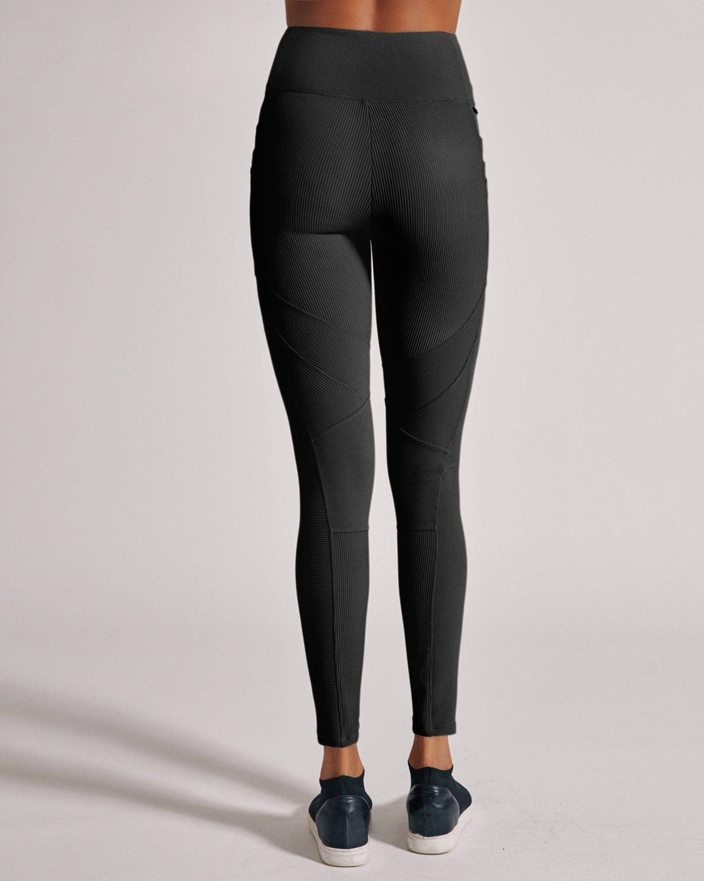 Black leggings worn by a person on a light gray background