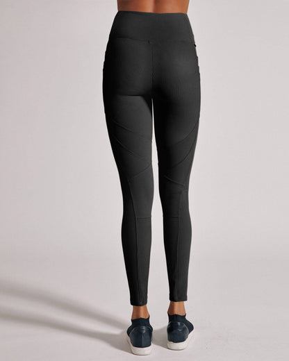 Black leggings worn by a person on a light gray background