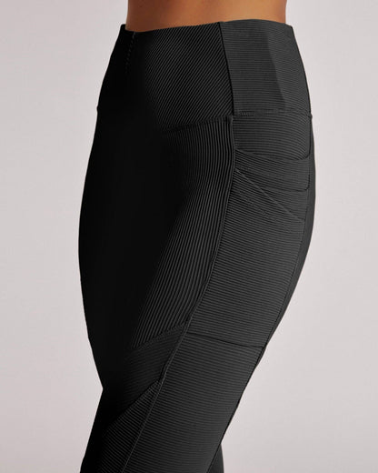 Black leggings with a textured pattern on a light gray background