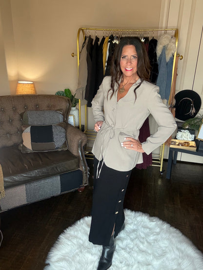 Angled view of the taupe Perfect Layer Lightweight Tie Blazer styled with a white top, black midi skirt and black boots.