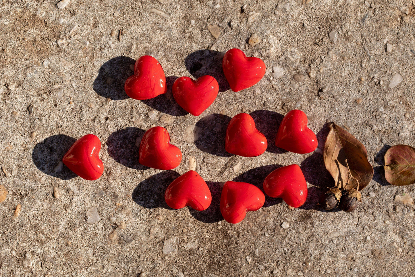 Red heart-shaped objects on a concrete surface