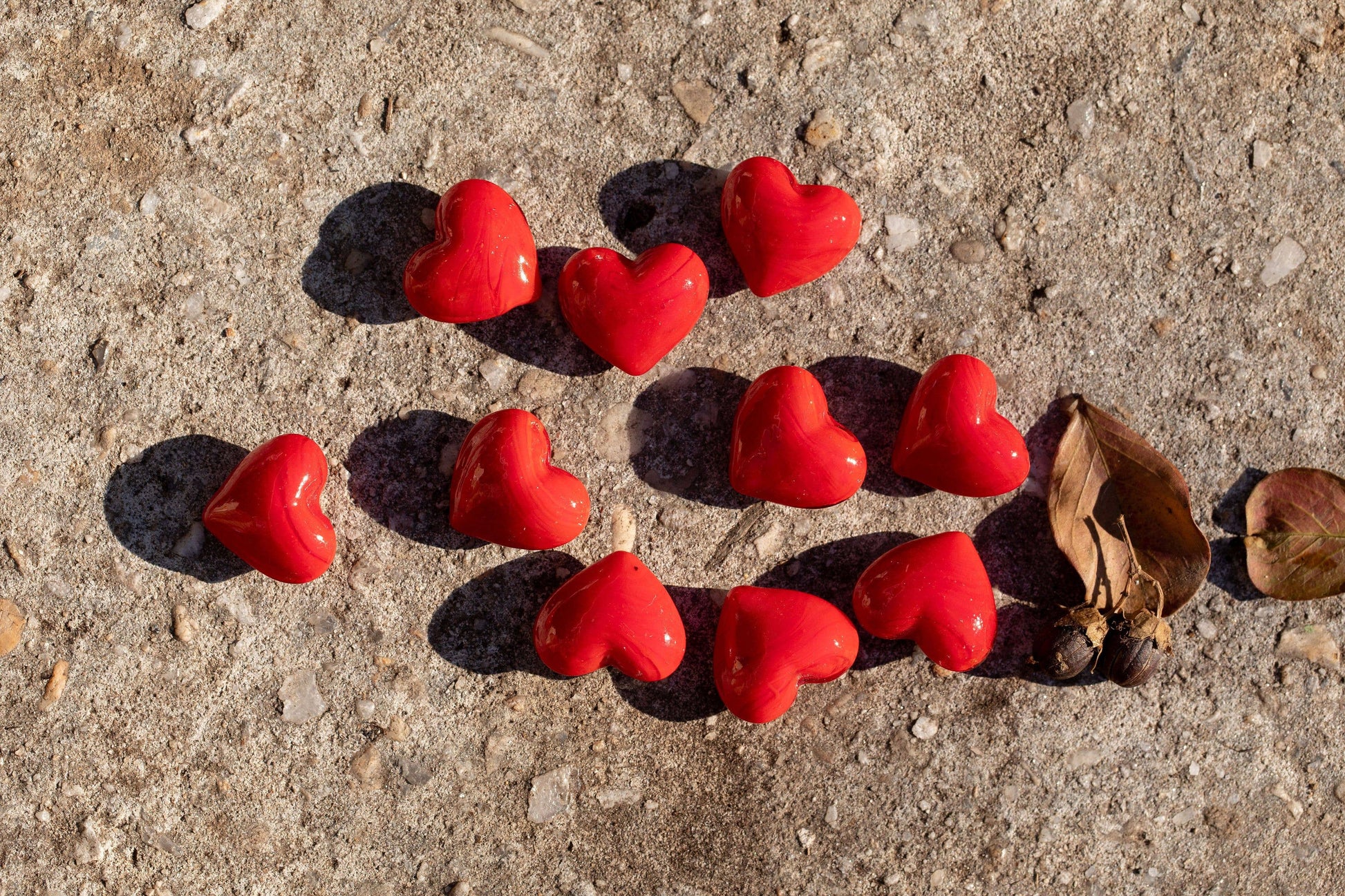 Red heart-shaped objects on a concrete surface