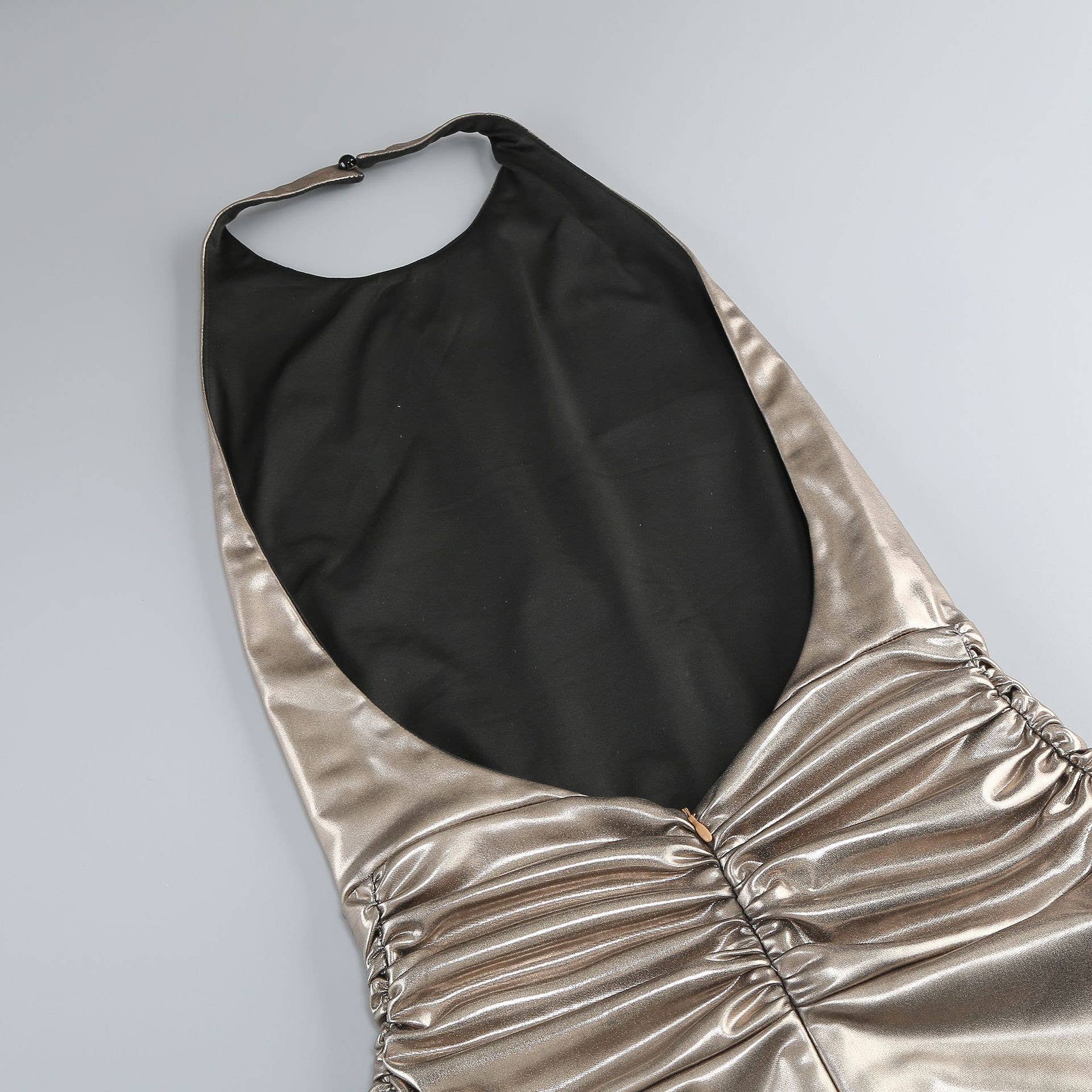 Gold and black halter top on a light gray background
