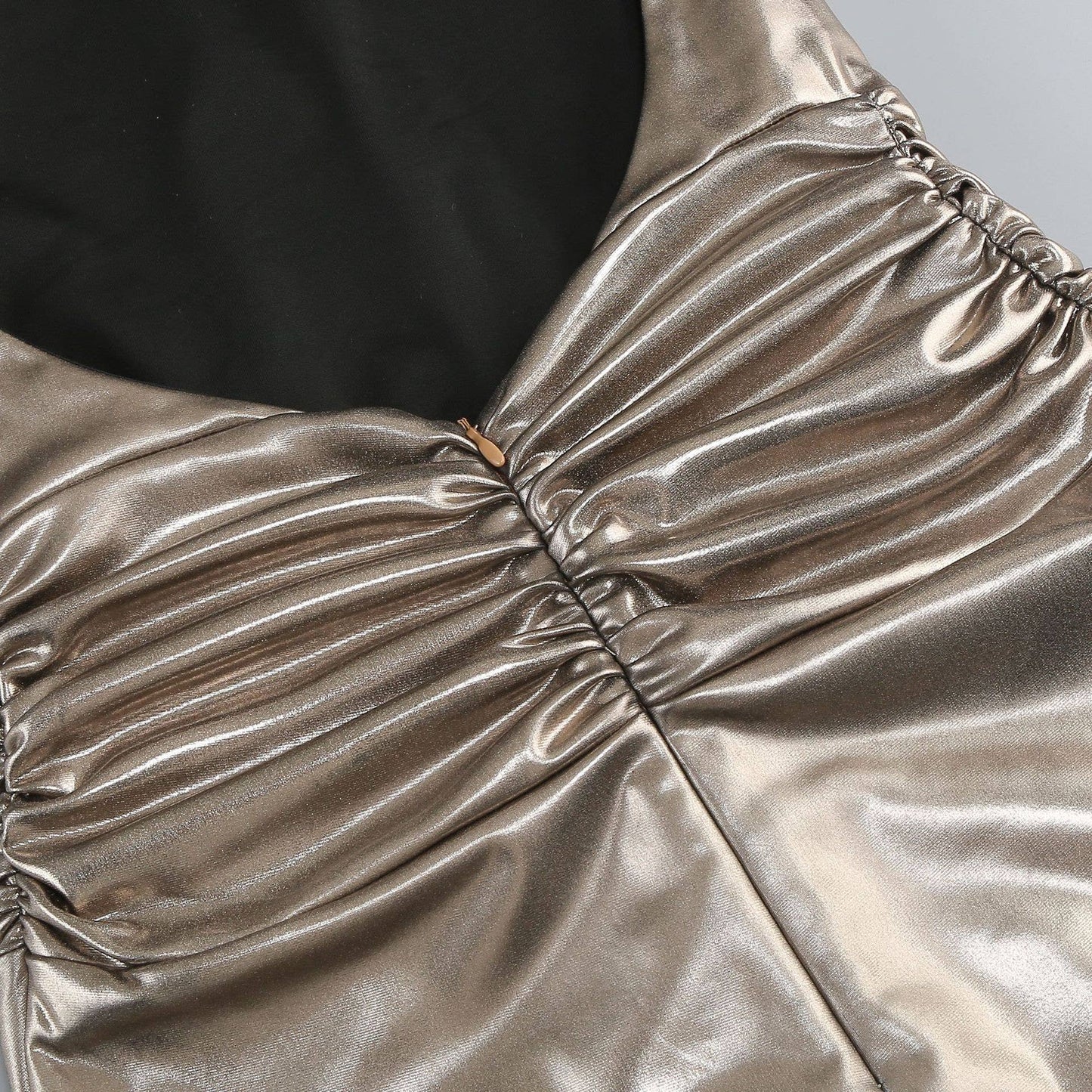 Close-up of a metallic gold dress with ruched details.