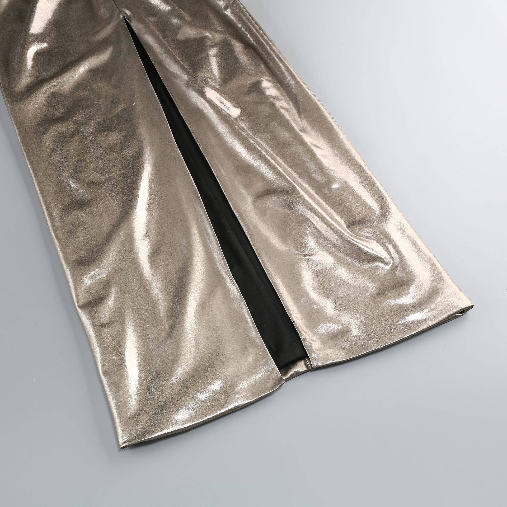 Metallic silver fabric with a black zipper on a light gray background