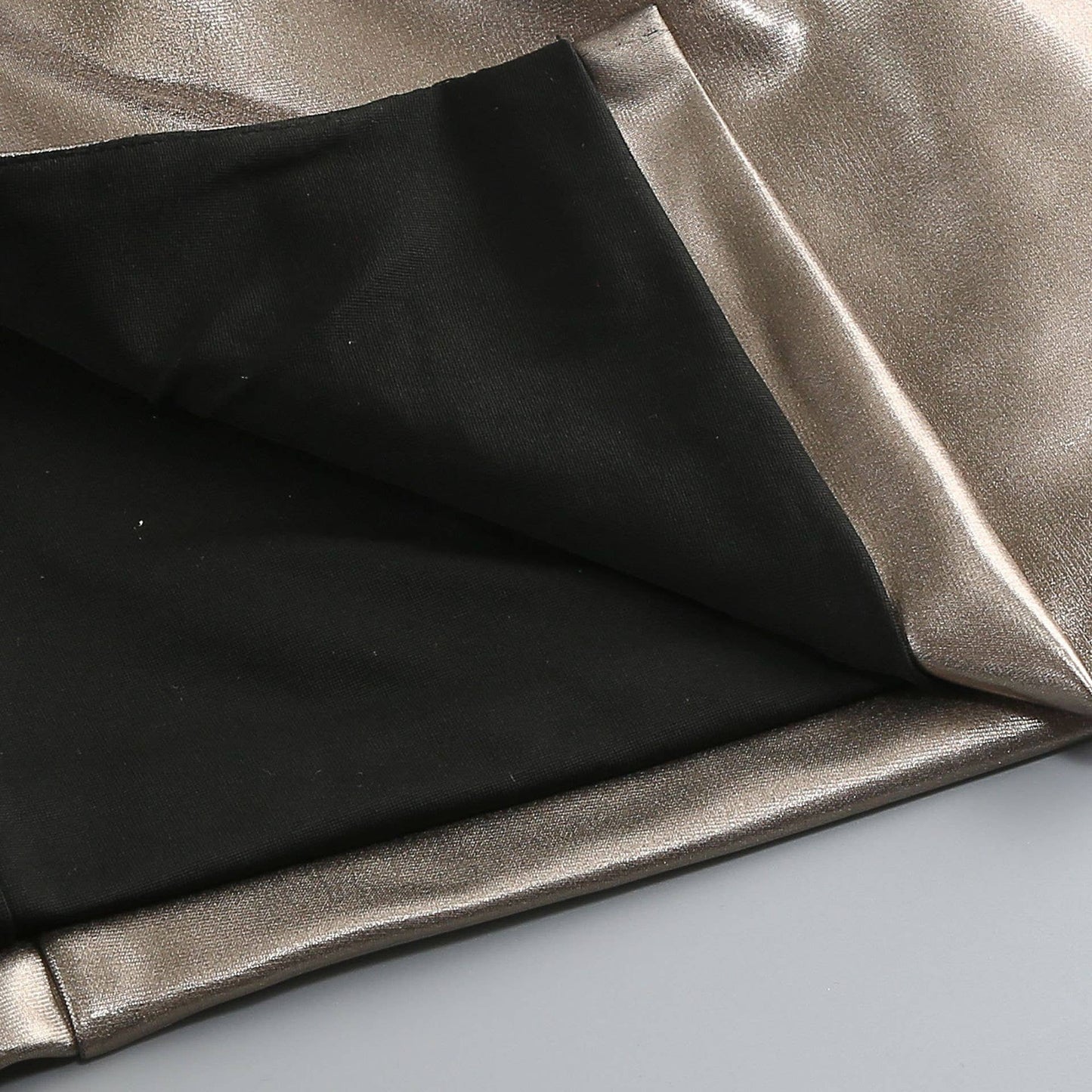 Close-up of black and metallic silver fabric on a light gray background