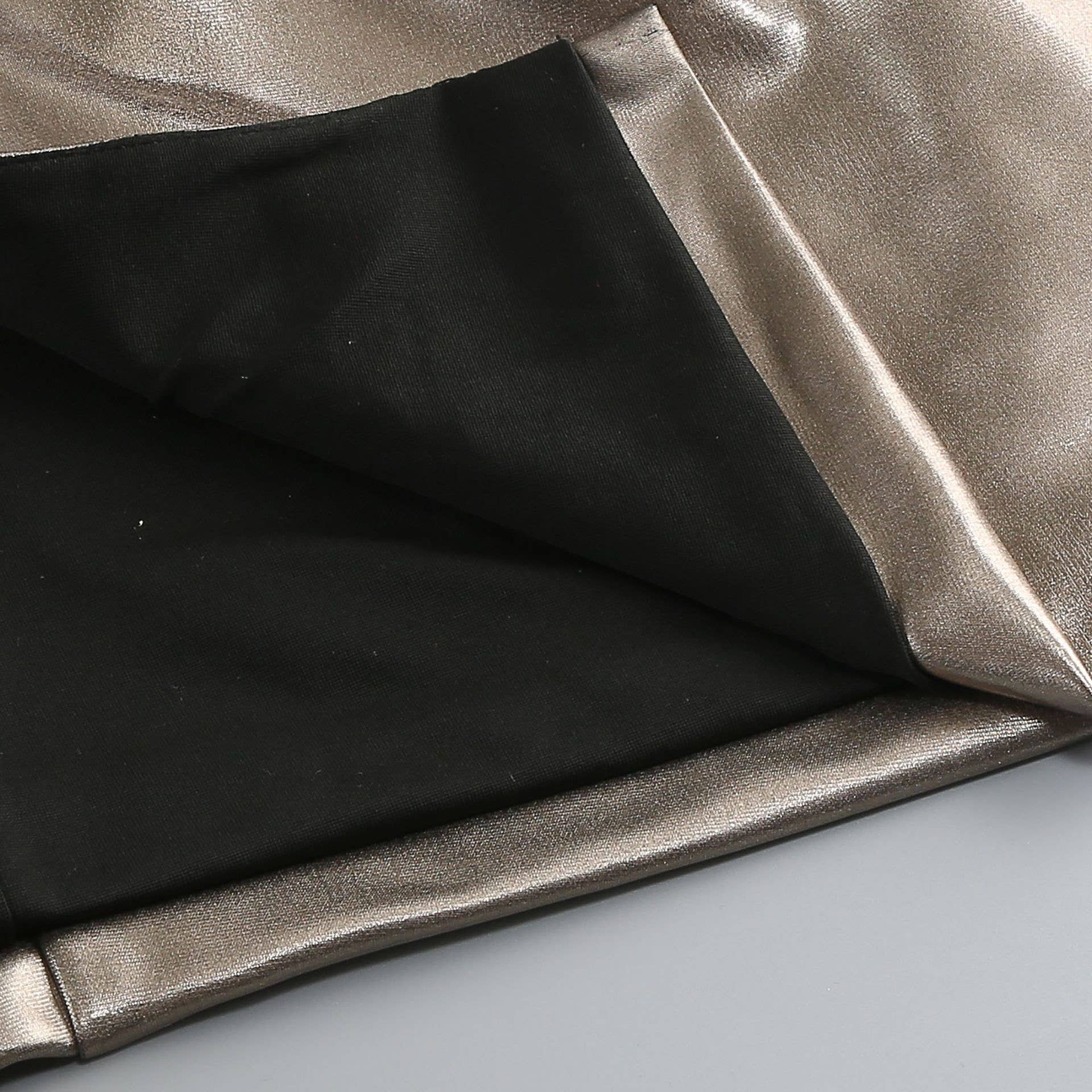 Close-up of black and metallic silver fabric on a light gray background