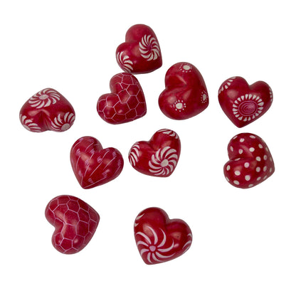 Red heart-shaped candies with various patterns on a white background