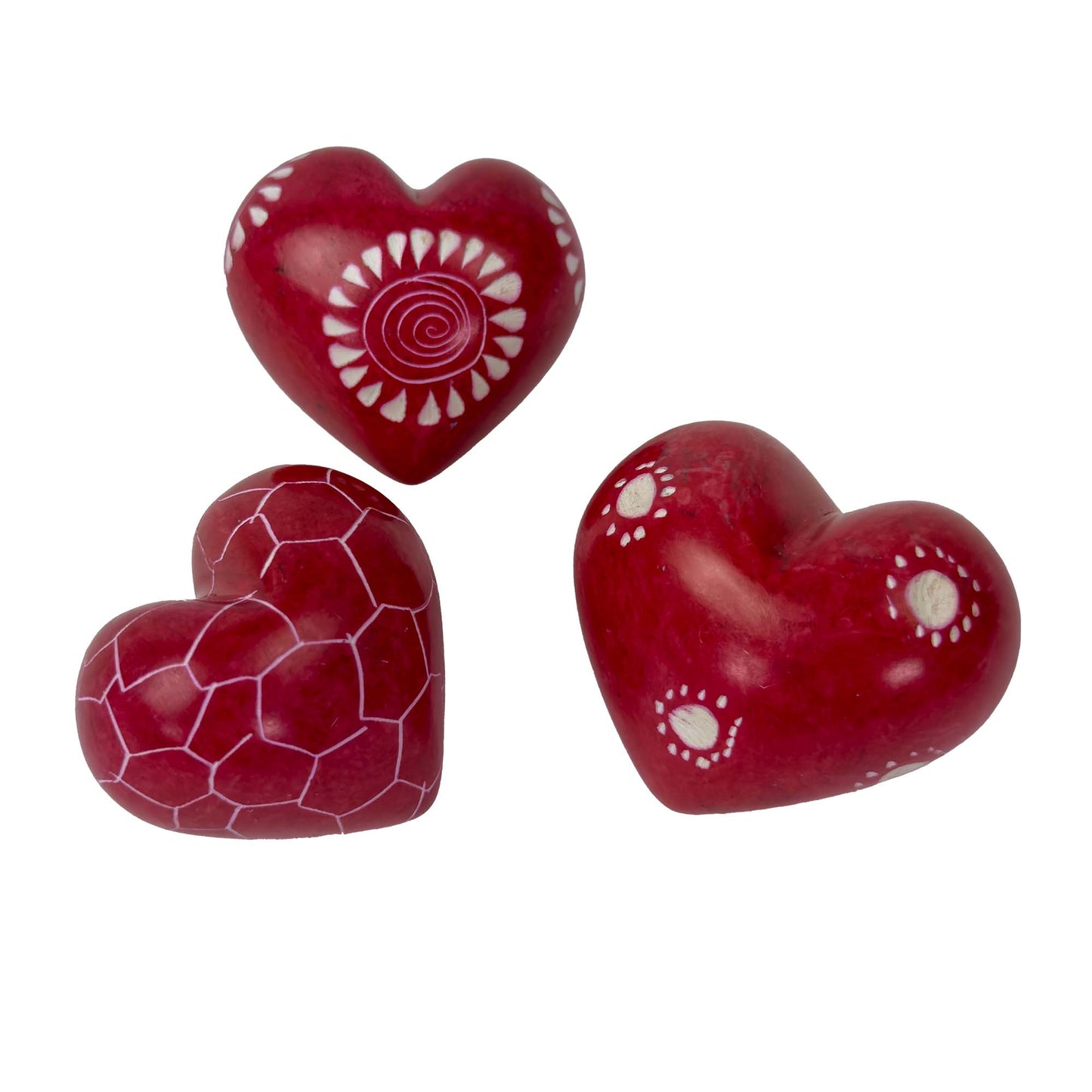 Three red heart-shaped objects with white patterns on a white background