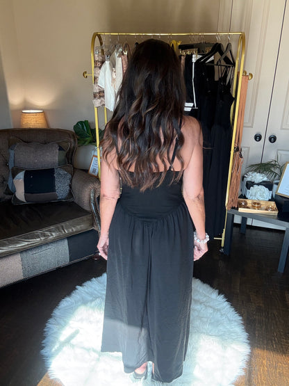 Person standing in a room with a mirror reflecting their back.