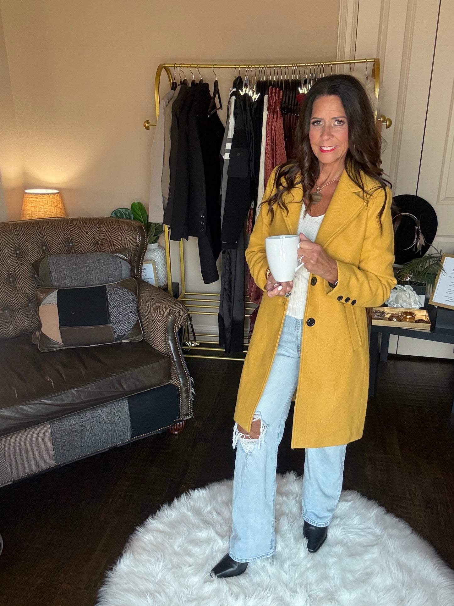 Model is wearing a yellow coat and jeans.