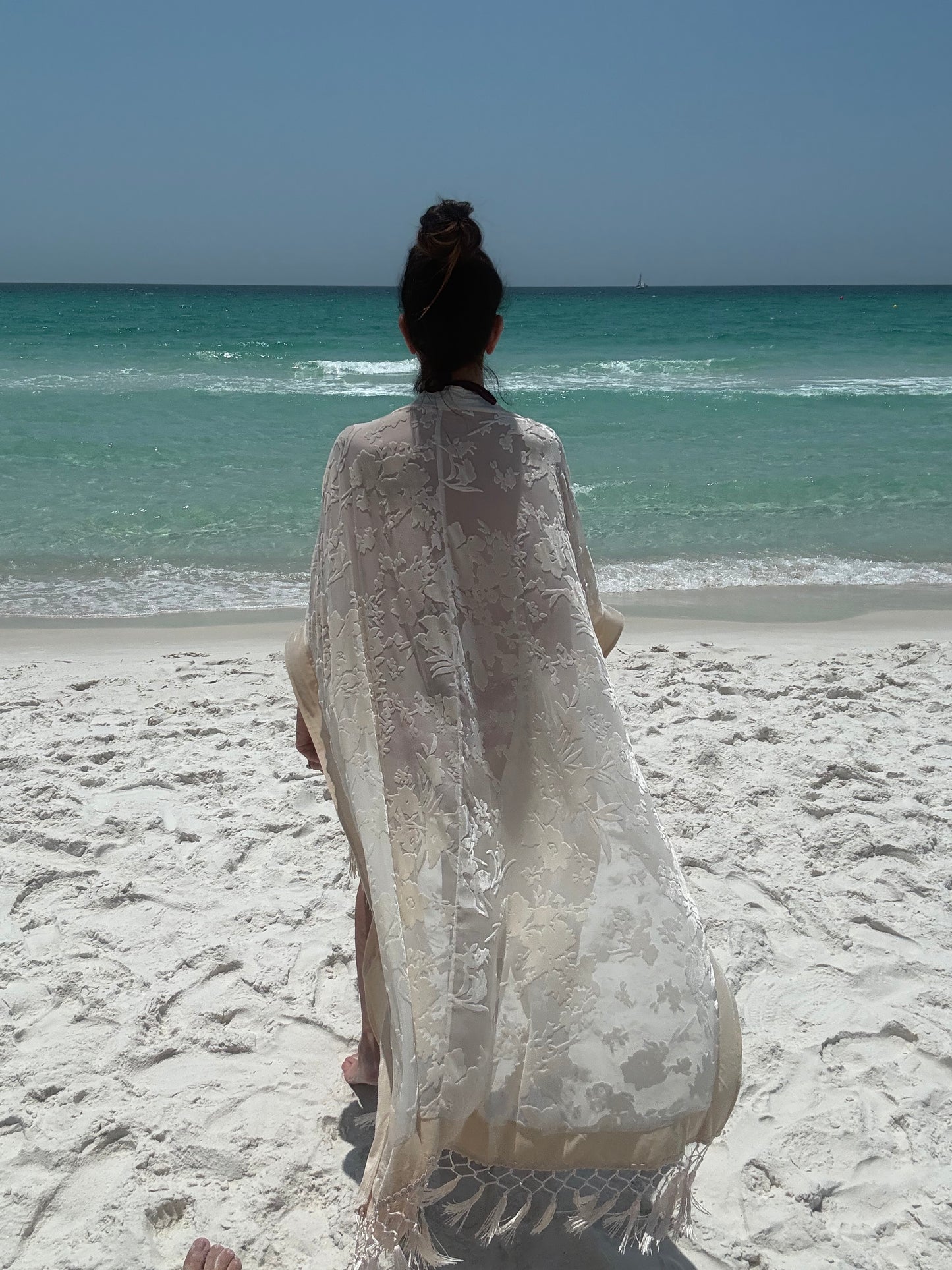 ivory kimono worn by womAN ON BEACH WIOTH OCEAN BACKGROUND