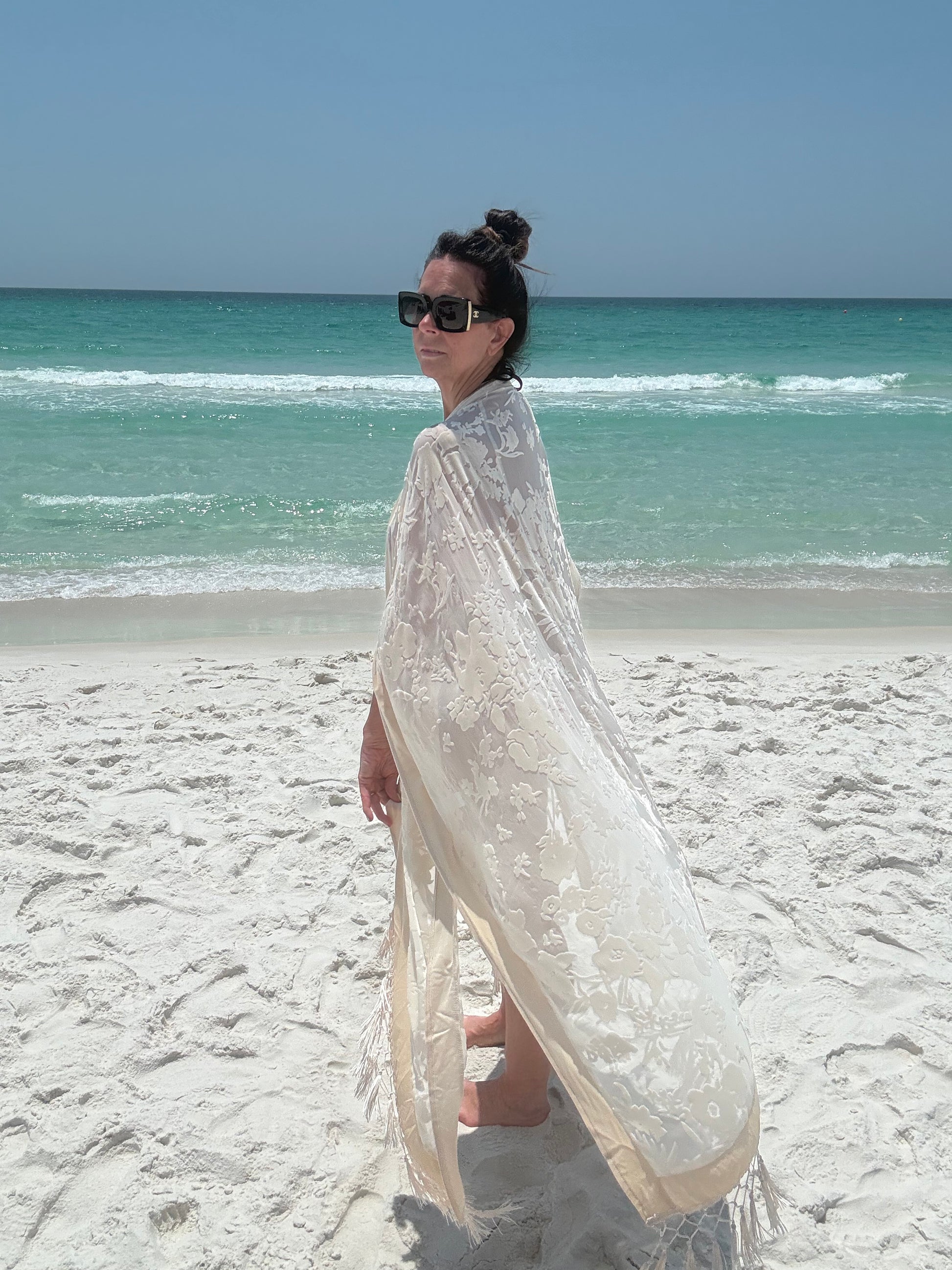 ivory kimono worn by womAN ON BEACH WIOTH OCEAN BACKGROUND