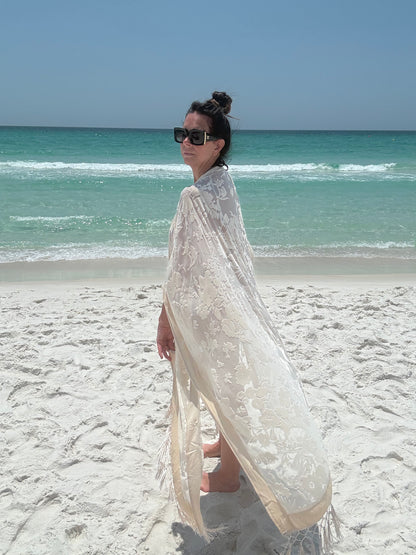 ivory kimono worn by womAN ON BEACH WIOTH OCEAN BACKGROUND