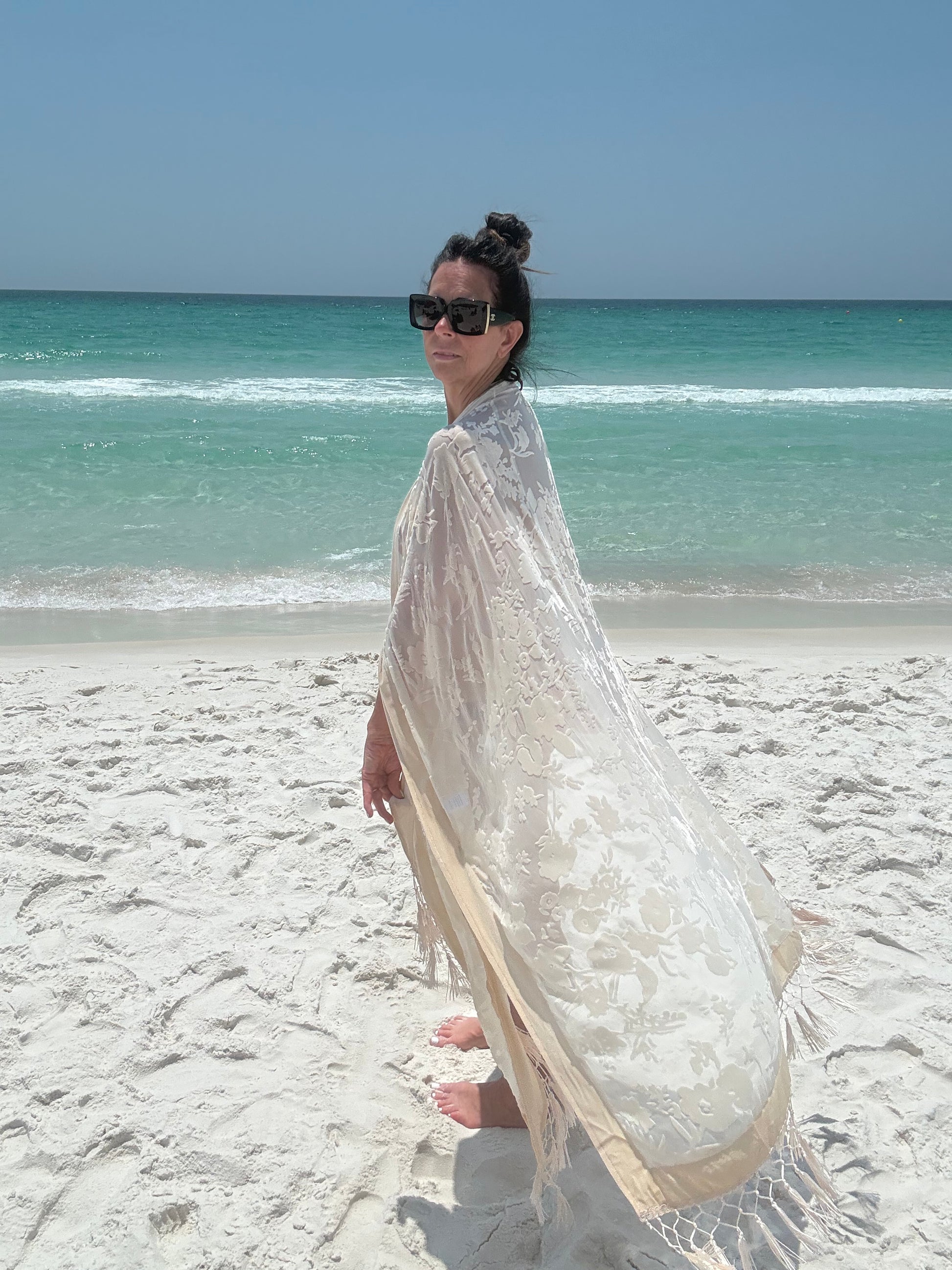 ivory kimono worn by womAN ON BEACH WIOTH OCEAN BACKGROUND