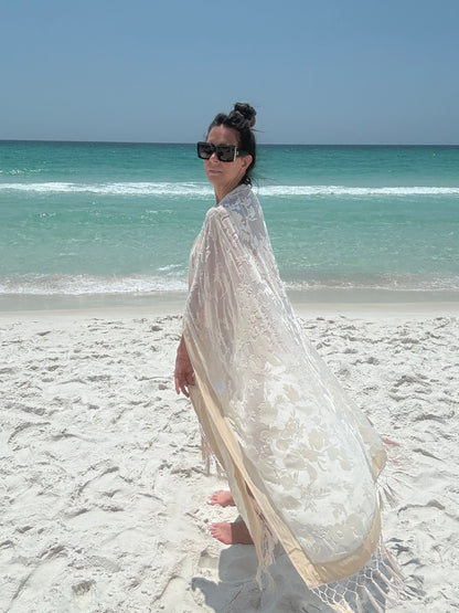 ivory kimono worn by womAN ON BEACH WIOTH OCEAN BACKGROUND