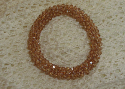 Brown beaded bracelet on a textured beige surface