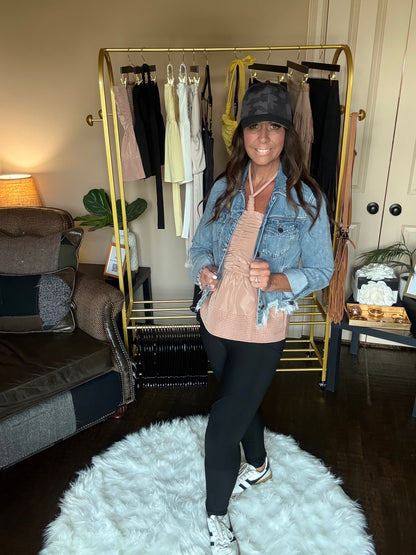 Person standing in a room with a gold mirror, clothing rack, and white rug.