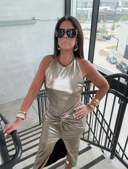 Woman in a metallic dress standing on a balcony with a cityscape background