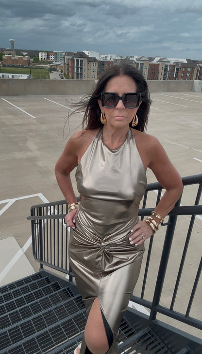Woman in a metallic dress standing on a rooftop with a cityscape background