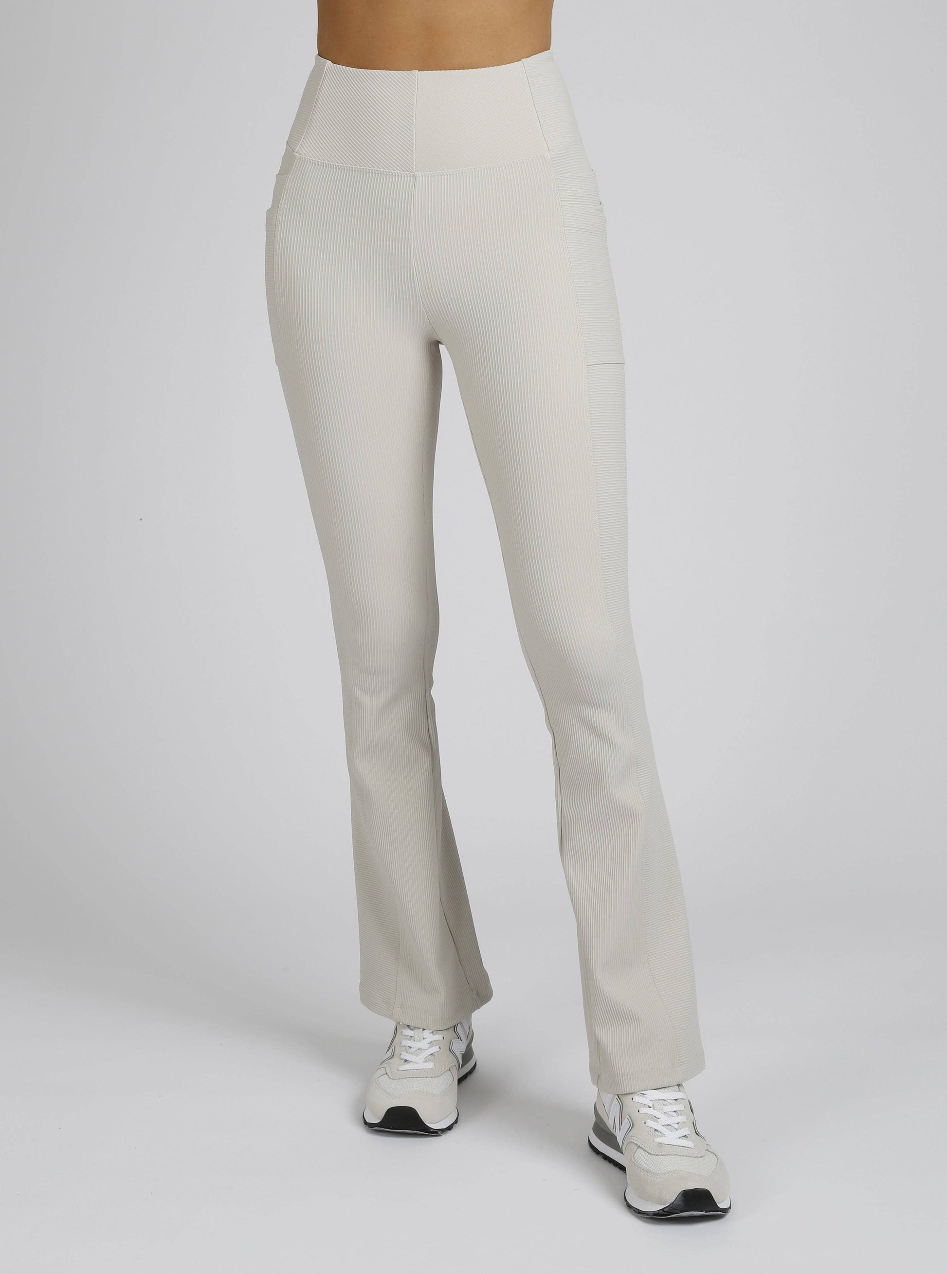 Beige pants worn by a person on a white background
