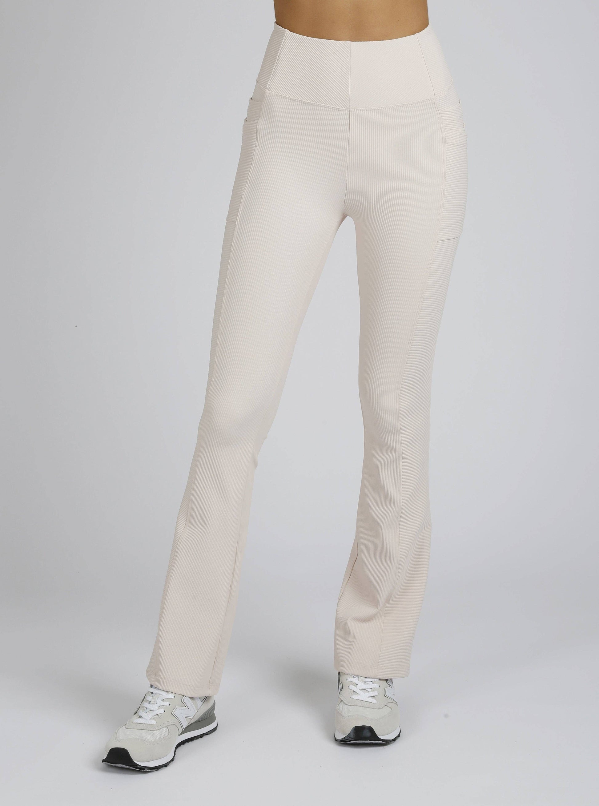 Beige pants worn by a person on a white background