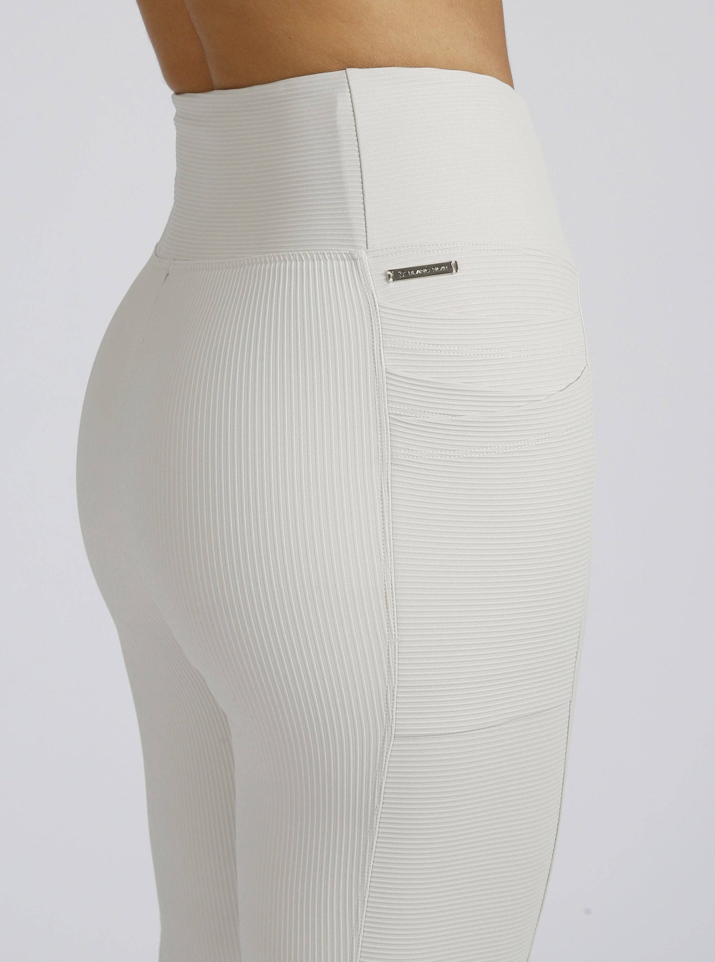 White ribbed leggings with a brand logo on a white background