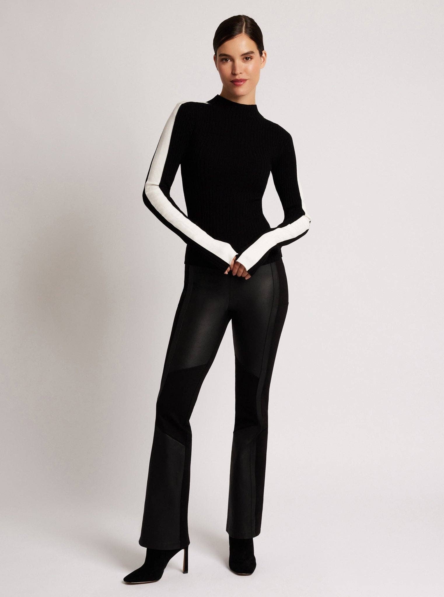 Person wearing a black and white outfit on a plain background