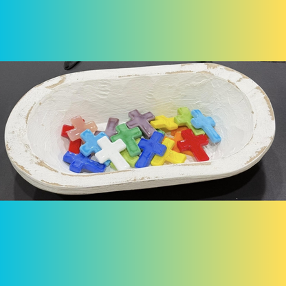 Colorful cross-shaped objects on a white dish with a gradient background