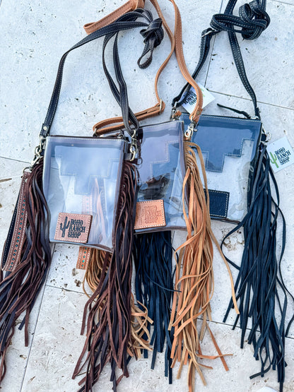 Three clear bags with fringe straps on a light surface