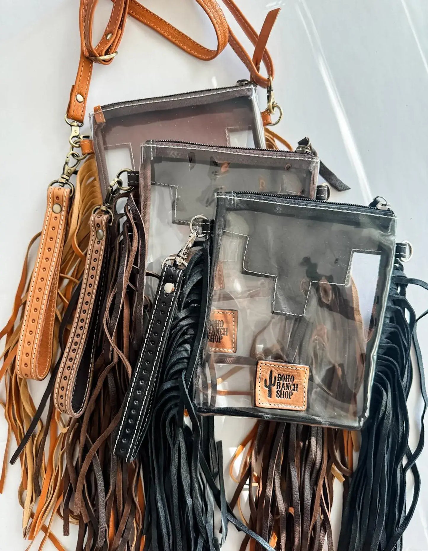 Clear handbags with leather straps and a visible brand logo on a white background