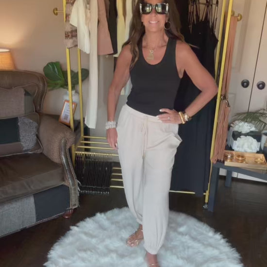 Woman is modeling tan harem pants.