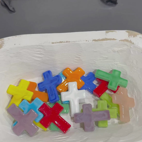 Hand picking up a white glass cross.