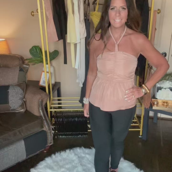 Movie of woman modeling a taupe halter top in a home boutique.