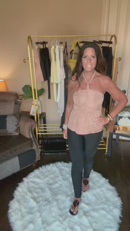 Movie of woman modeling a taupe halter top in a home boutique.
