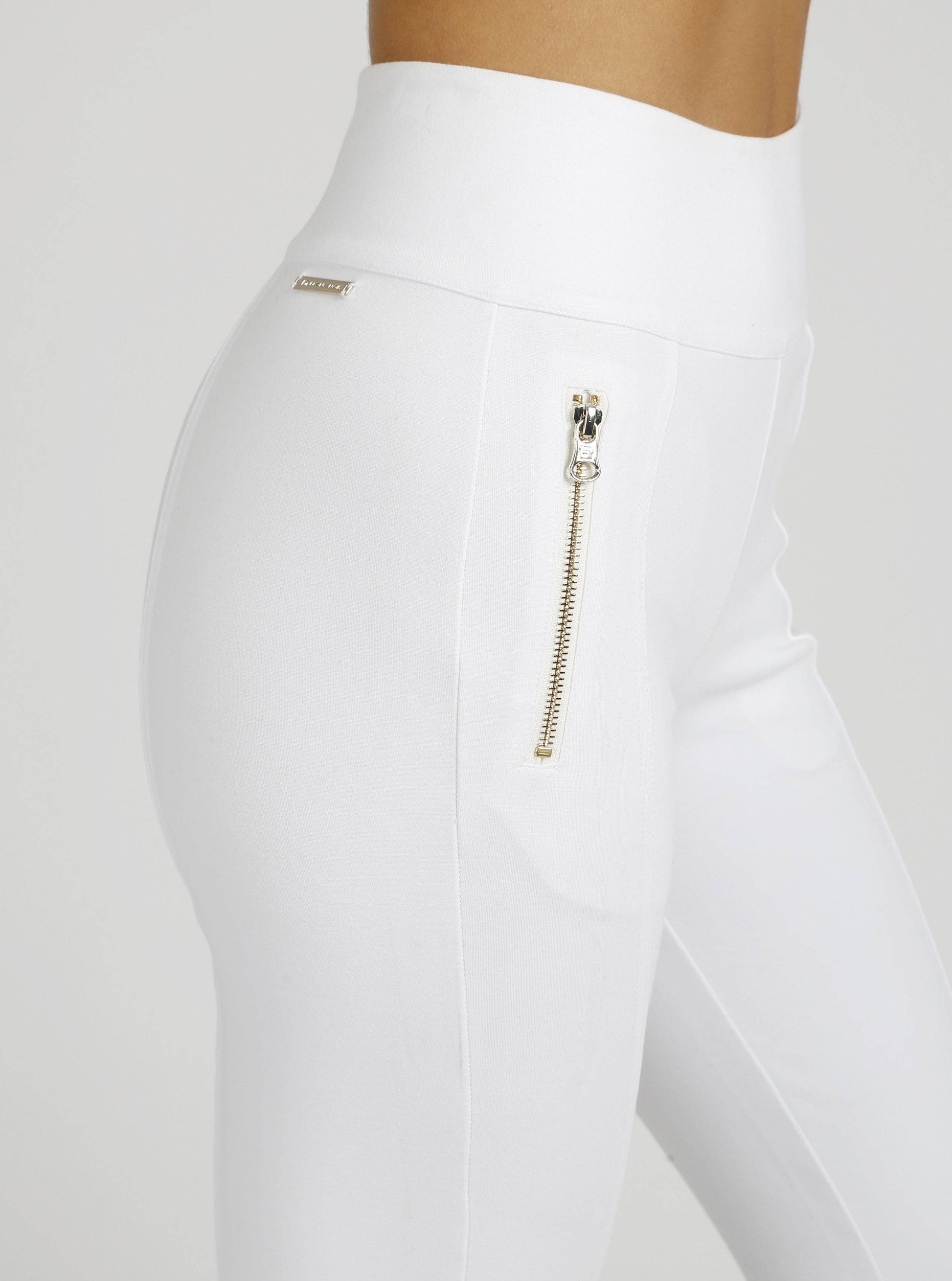 White leggings with a gold zipper on a white background